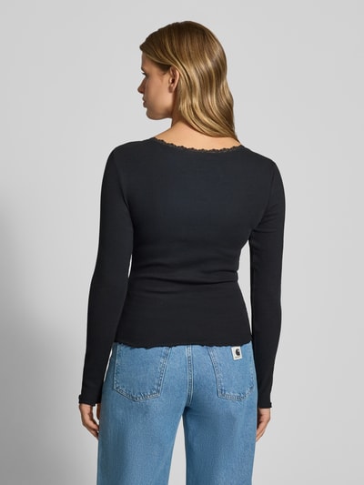 Kobiece model prezentuje Longsleeve mit Spitzenbesatz und Rundhalsausschnitt od REVIEW, czarny, mieszanka bawełny i elastanu, krój slim fit, efekt prążkowania, obszycie koronką, okrągły dekolt, długość tyłu w rozmiarze S: 50 cm, widok całej sylwetki z tyłu.