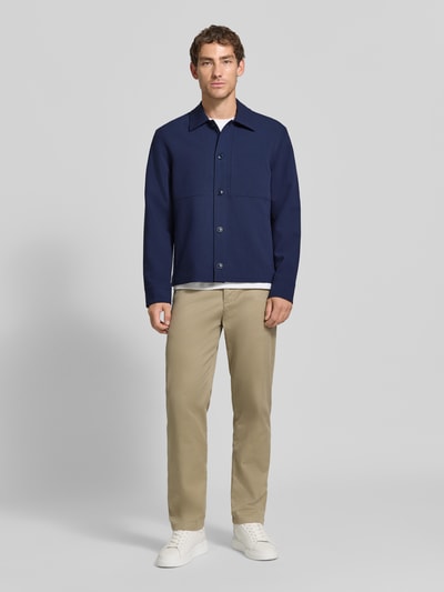 Männermodel trägt Regular Fit Hemdjacke mit Viskose-Anteil von Jake*s Studio Men in Dunkelblau, helle Hose, weiße Sneaker, Ganzkörperansicht von vorne.
