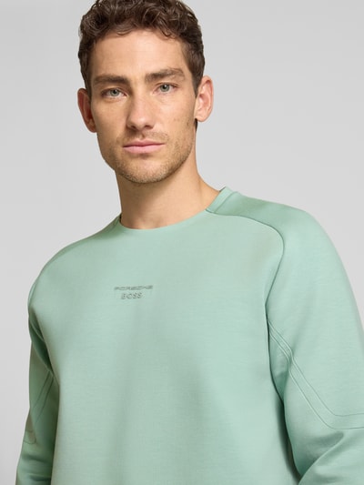 Männermodel trägt Regular Fit Sweatshirt aus Baumwoll-Mix Modell 'SW_PS SPIRIT70 CN' von BOSS Green X Porsche, unifarben, Nahaufnahme Oberkörper.