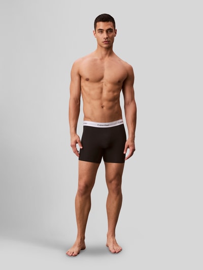Männermodel trägt Pant & Trunk mit elastischem Label-Bund im 3er-Pack von Calvin Klein Underwear, Schwarz-Weiß, Baumwoll-Elasthan-Mix, Ganzkörperansicht von vorne.