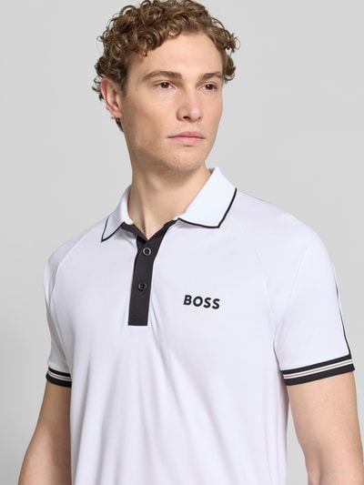 Männermodel trägt Regular Fit Poloshirts mit Kontrastdetails von BOSS Green, Two-Tone-Optik, Polokragen, 2-Knopf-Verschluss, Nahaufnahme Oberkörper.