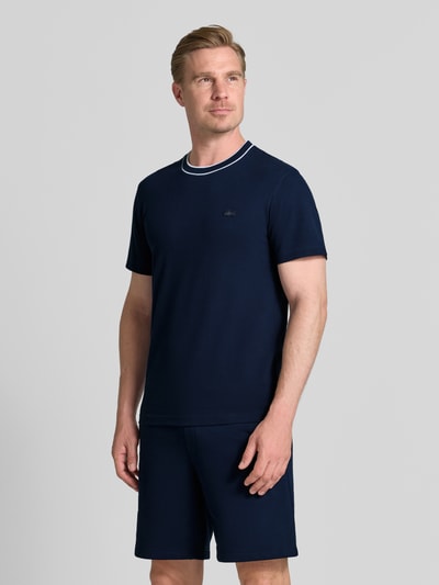 Männermodel trägt dunkelblaues Regular Fit T-Shirt aus Baumwoll-Mix Modell 'CREATOR' von Lacoste, Herren T-Shirt. Ganzkörperansicht von vorne.