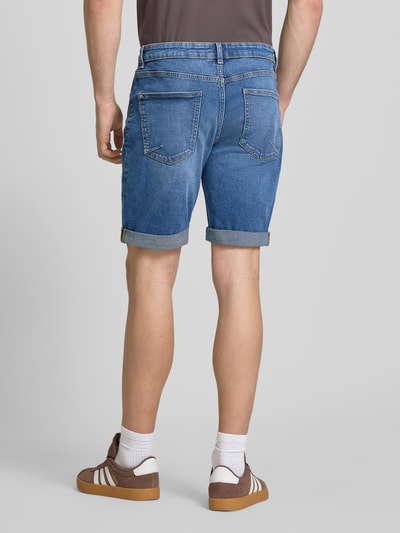 Männermodel trägt Slim Fit Jeansshorts mit Umschlag von REVIEW, blaue Baumwoll-Elasthan-Mix, Rückansicht, Ganzkörperansicht.