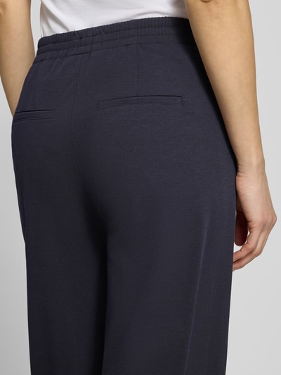 Frauenmodel trägt Hose mit Eingrifftaschen Modell 'FAE' von Drykorn aus reiner Baumwolle in Dunkelblau, Detailaufnahme Rückansicht.