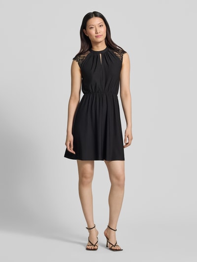 Frauenmodel trägt Tailliertes Freizeitkleid mit Spitzenbesatz Modell 'MILLA' von Vero Moda, Optik: Unifarben, Mini-Länge, Hochgeschlossen, Kurzarm, Materialverarbeitung: Stretch, Ganzkörperansicht von vorne.