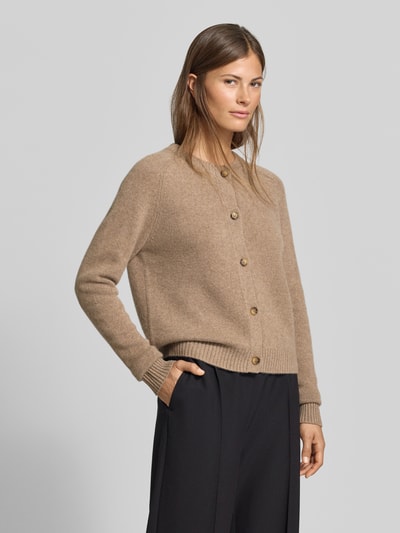 Frauenmodel trägt Strickjacke aus reinem Kaschmir von MYON, beige Farbe, Knopfleiste, Rundhalsausschnitt, gerade Passform, Ganzkörperansicht von vorne.