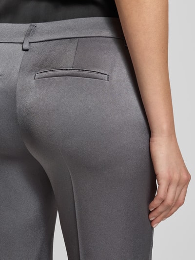 Frauenmodel trägt Flared Stoffhose mit Bundfalten von Luisa Cerano, Material-Mix, Gesäßtaschen, grau glänzend, Detailaufnahme Rückansicht.