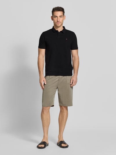 Męski model nosi Regular Fit Poloshirt mit Logo-Stitching od HECHTER PARIS z bawełny, fakturowany wzór, kołnierzyk polo, krótki rękaw, długość tyłu 66 cm, widok całej sylwetki z przodu.