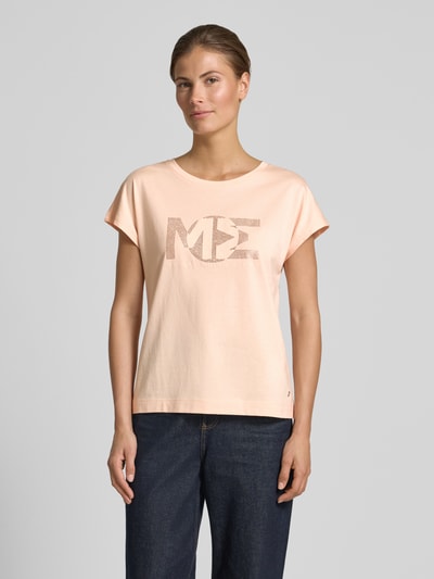 Frauenmodel trägt Regular Fit T-Shirt mit Ziersteinbesatz von monari aus Baumwoll-Modal-Mix in zartem Apricot, Rundhalsausschnitt, Rückenlänge bei Größe 36: 57 cm, Ganzkörperansicht von vorne.