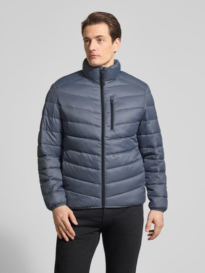 Männermodel trägt Regular Fit Steppjacke mit vertikaler Reißverschlussbrusttasche von Tom Tailor Denim, Optik: Unifarben, Stehkragen, Reißverschluss, Langarm, paspelierter Rumpfabschluss, seitliche Eingrifftaschen, glatte Struktur, Ganzkörperansicht von vorne.