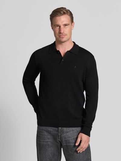 Mannelijk model draagt zwart slim fit poloshirt uit pure katoen van ARMEDANGELS, eenvoudige structuur, Ganzkörperansicht von vorne.