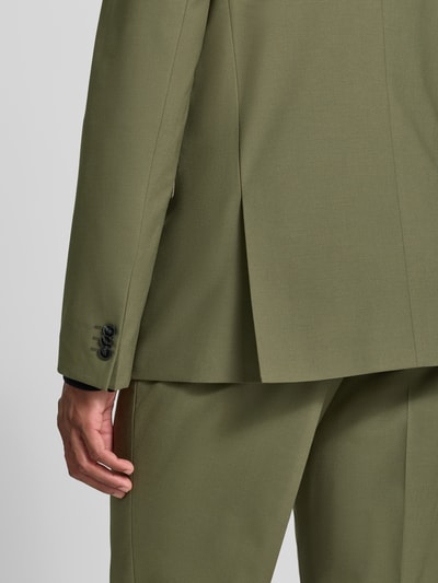 Männermodel trägt Super Slim Fit Sakko aus Woll-Mix Modell 'Arti 253X' von HUGO in Olivgrün, glatte Textur, Ganzkörperansicht Rückansicht.