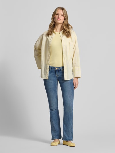 Frauenmodel trägt Low Rise Flared Jeans im 5-Pocket-Design Modell 'JOEY' von TRUE RELIGION im Baumwoll-Mix mit Viskose, mittleres Blau, Ganzkörperansicht von vorne.