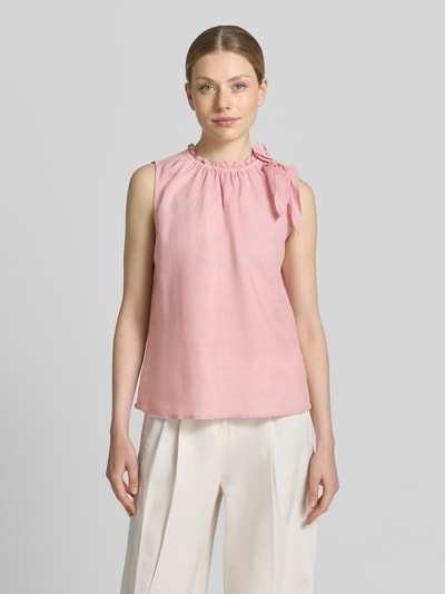 Frauenmodel trägt Regular Fit Bluse aus Viskose-Mix mit Leinen-Anteil von Christian Berg Woman in Rosa mit Zierschleife, Stehkragen mit Rüschenbesatz, Ärmelloses-Design, Rückenlänge bei Größe 36: 54 cm, Ganzkörperansicht von vorne.