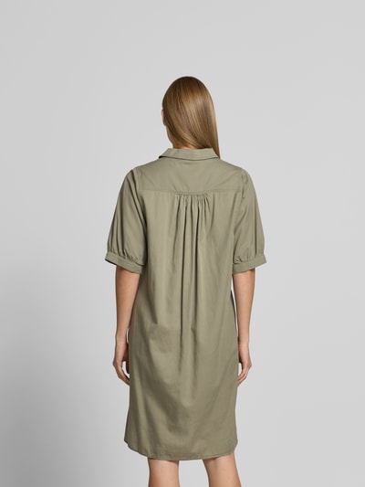 Frauenmodel trägt Relaxed Fit Hemdkleid im Halbarm-Design von Juvia in Khaki, reine Baumwolle, mit Hemdblusenkragen, Ganzkörperansicht Rückansicht.