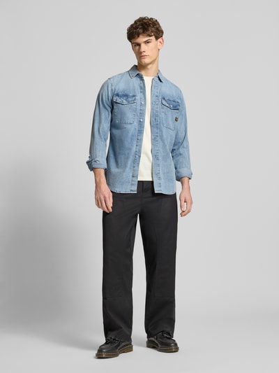Męski model nosi Slim Fit Freizeithemd aus reiner Baumwolle Modell 'Marine' von G-Star Raw, błękit, krój slim fit, długie rękawy, guzik, kieszenie na piersi, detal z logo, koszula, bawełna, widok całej sylwetki z przodu. Szerokość w rozmiarze M: 40 cm, długość tyłu: 75 cm, długość rękawa: 67 cm.
