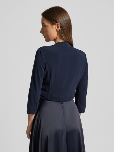 Frauenmodel trägt Bolero mit offener Vorderseite von VM Vera Mont, dunkelblauer Material-Mix mit Stretch-Anteil, Gerader-Schnitt, Sportmanschetten, Rückenlänge bei Größe 36: 42 cm, Ganzkörperansicht Rückansicht.