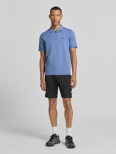 Männermodel trägt Regular Fit Poloshirt aus reiner Baumwolle Modell 'KN_EVER-X' von BOSS Green in Optik: Unifarben, Ganzkörperansicht von vorne.