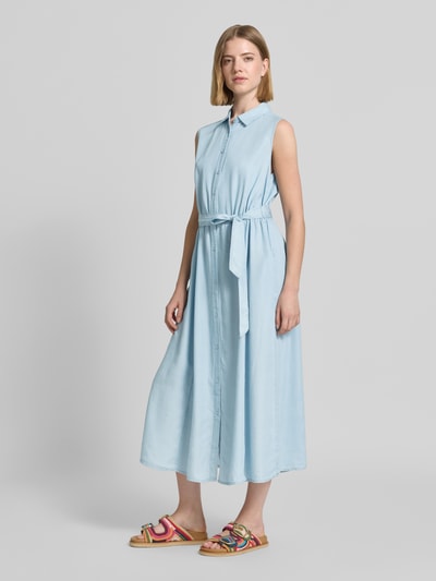 Frauenmodel trägt Hemdblusenkleid mit Bindegürtel Modell 'LIV' von Soyaconcept aus reiner Baumwolle in Hellblau, Midilänge, taillierter Schnitt, Hemdblusenkragen, Knopfleiste, Struktur fein und glatt, Ganzkörperansicht von vorne.