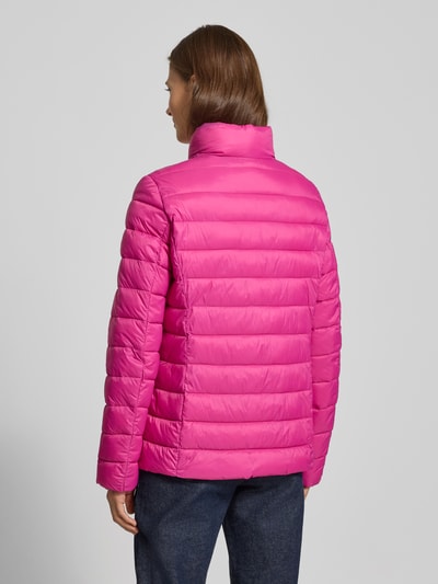 Vrouwenmodel draagt Gewatteerd jack met opstaande kraag van Christian Berg Woman Selection in regular fit, ruglengte 64 cm, schouderbreedte 41 cm, borstwijdte 52 cm, mouwlengte 64 cm, felle roze kleur, gladde textuur, rits en ritszakken, ganzebodyaanzicht achteraan.