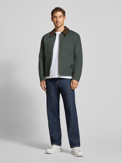 Männermodel trägt Regular Fit Jacke aus reiner Baumwolle von MCNEAL in Dunkelgrün mit Umlegekragen, Ganzkörperansicht von vorne. Rückenlänge 67 cm, Schulterbreite 53 cm, Brustweite 60 cm, Ärmellänge 66 cm.