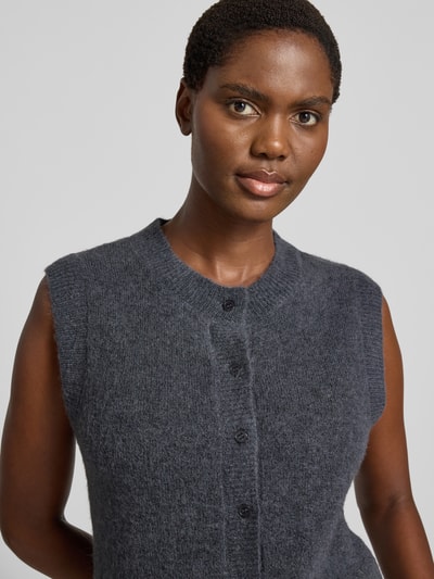 Frauenmodel trägt Strickweste mit Rundhalsausschnitt Modell 'Bondie Hope' von MSCH Copenhagen in Dunkelgrau, wollige Textur, Nahaufnahme Oberkörper, Damen Strickweste Regular Fit, Knopfleiste, Rückenlänge 58 cm, Mix mit Woll-Anteil.