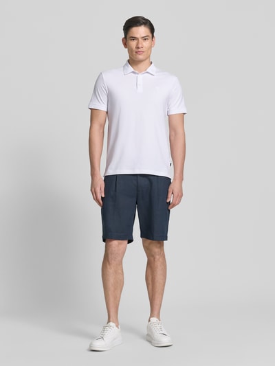 Męski model nosi koszulkę polo Regular Fit Poloshirt mit Knopfleiste Modell 'Carlosjuan' von JOOP! Collection, mieszanka bawełny z dodatkiem streczu, krój regular fit, kołnierzyk polo, krótka listwa guzikowa, długość tyłu w rozmiarze M: 69 cm, cała sylwetka z przodu