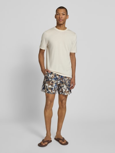 Männermodel trägt Shorts im Allover-Look mit elastischem Bund von ARMANI EXCHANGE, bunter Print, Regular Fit, Ganzkörperansicht von vorne.
