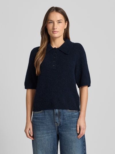 Frauenmodel trägt Regular Fit T-Shirt mit Alpaka-Lanawoll-Anteil Modell 'Alpha' von Gestuz, Polo-Kragen, Halbarm, Dunkelblau, Strick-Optik, Ganzkörperansicht von vorne.