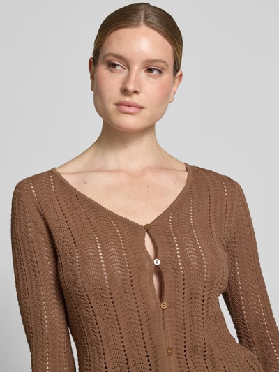 Frauenmodel trägt Cardigan mit V-Ausschnitt und Knopfleiste von Rich & Royal aus Reine Baumwolle, Ajour, Straight, Trompetenärmel, Nahaufnahme Oberkörper.