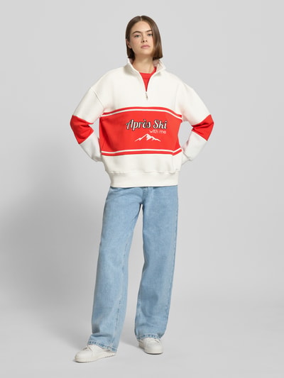 Frauenmodel trägt Relaxed Fit Sweatshirt mit Stehkragen Modell 'Jenny' von LeGer by Lena Gercke in Weiß und Rot, Ganzkörperansicht von vorne.