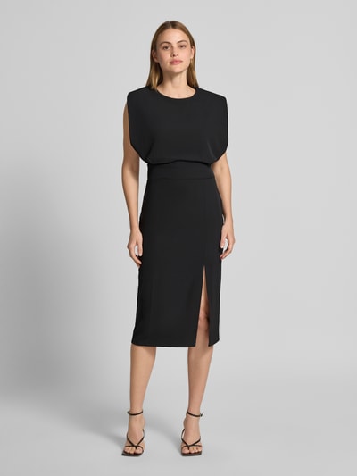 Frauenmodel trägt Cocktailkleid mit Gehschlitz von Rinascimento in Schwarz, körpernaher Schnitt, strukturierte Oberfläche, Ganzkörperansicht von vorne.