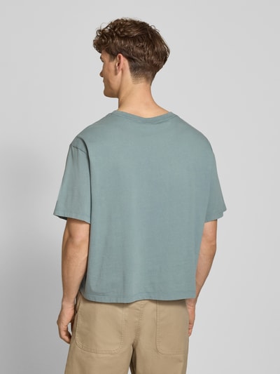 Männermodel trägt Relaxed Fit T-Shirt aus reiner Baumwolle von Calvin Klein Jeans, Optik: Unifarben, Ganzkörperansicht Rückansicht.