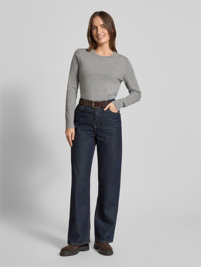 Vrouwenmodel draagt Regular Fit Strickpullover aus Baumwoll-Mix van Tommy Hilfiger, grijs, uni kleur, ribgebreid, lange mouwen, logo detail, katoenmix, geribde boorden, ronde hals, vooraanzicht volledige lichaamsopname.