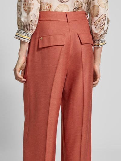 Frauenmodel trägt Wide Fit Hose aus Viskose-Elasthan-Mix von Marc Cain in Rostrot mit Bügelfalten, High-Waist, Struktur. Ganzkörperansicht Rückansicht. Damen Hose, Bundweite 36 cm, Innenbeinlänge 82 cm, Größe 36.