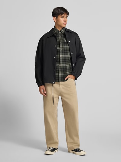 Männermodel trägt Regular Fit Freizeithemd aus reiner Baumwolle von Superdry in Grün mit Button-Down-Kragen und Brusttasche, Ganzkörperansicht von vorne.