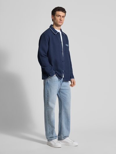 Männermodel trägt Relaxed Hemdjacke mit Strukturmuster von Scotch & Soda, reine Baumwolle, dunkelblau, Knopfleiste, Ganzkörperansicht von vorne.