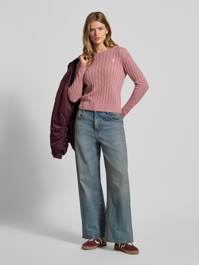 Vrouwenmodel draagt Slim Fit Strickpullover met ronde hals en kabelpatroon van Review, katoenmix, roze tint, volledige lichaamsvooraanzicht.