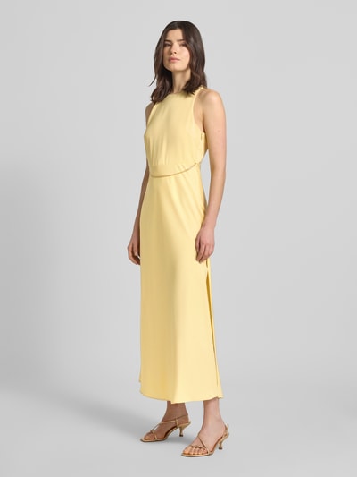 Frauenmodel trägt Maxikleid mit Ketten-Detail von ARMANI EXCHANGE aus Satin in Gelb, taillierter Schnitt, Rundhalsausschnitt, Ganzkörperansicht von vorne.