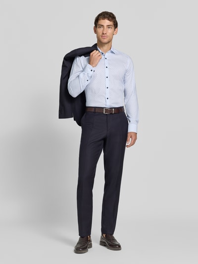 Männermodel trägt Body Fit Businesshemd aus Baumwoll-Mix von OLYMP Level 5 in Hellblau mit feinem Muster, dunkle Hose, Ganzkörperansicht von vorne.