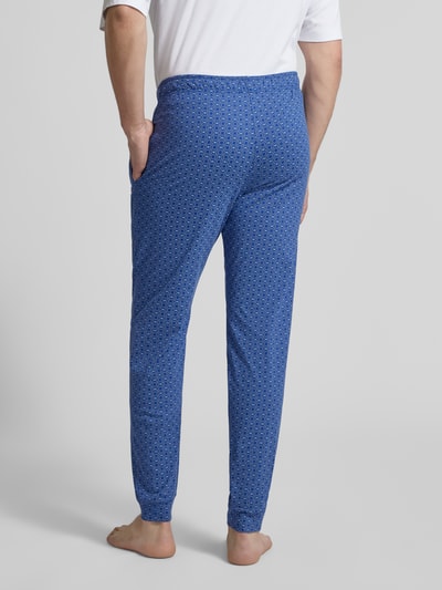 Männermodel trägt Pyjama-Hose im Allover-Look von Schiesser in Blau mit Muster, Regular Fit, elastischer Bund, Ganzkörperansicht Rückansicht.