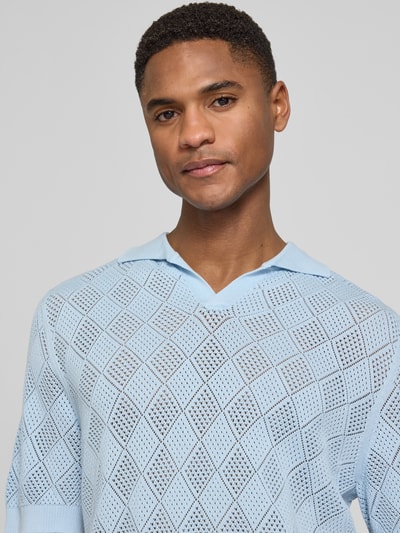 Männermodel trägt Regular Fit Poloshirt aus reiner Baumwolle Modell 'ARCO' von SELECTED HOMME in Hellblau mit Lochstrickmuster, Nahaufnahme Oberkörper.
