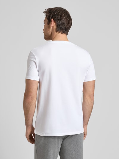 Męski model ma na sobie T-Shirt mit Logo und Rundhalsausschnitt von JOOP! Collection, bawełniano-elastanowy, krój regular fit, długość tyłu w rozmiarze M: 69 cm, biała gładka tkanina, widok całej sylwetki z tyłu