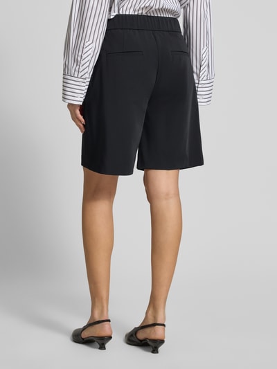 Frauenmodel trägt Schlupfbermuda Techno Cotton Superstretch von Raffaello Rossi, Regular-Fit, Elastischer Bund, Gesäßtaschen, Modell 'ISKA', Schwarz, Ganzkörperansicht Rückansicht, Bundweite bei Größe 36: 39 cm, Innenbeinlänge bei Größe 36: 24 cm.
