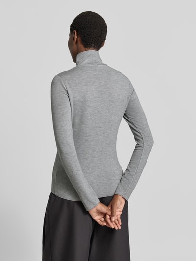 Frauenmodel trägt Longsleeve mit Rollkragen von someday im Viskose-Mix, Grau mit Ripp-Struktur, enganliegend, Ganzkörperansicht Rückansicht.