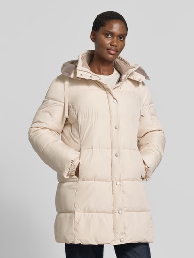 Frauenmodel trägt Steppmantel mit abnehmbarer Kapuze von White Label in Beige, Reiß- und Druckknopfverschluss, Ganzkörperansicht von vorne. Gerader Schnitt, Kapuze mit Tunnelzug, seitliche Reißverschlusstaschen, Rückenlänge 88 cm, Schulterbreite 42 cm, Brustweite 56 cm, Ärmellänge 65 cm.