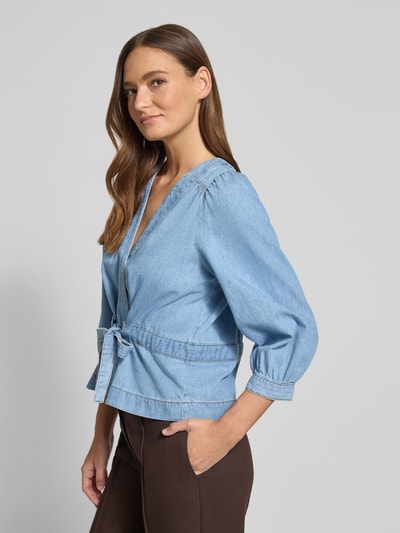 Frauenmodel trägt Relaxed Fit Bluse in Denim-Optik Modell 'Lavina' von Bash, reine Baumwolle, 3/4-Arm, taillierte Passform, seitliche Ansicht