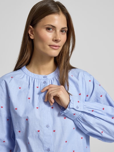 Vrouwenmodel draagt Overhemdblouse met knoopsluiting van Oui, puur katoen, los model, ronde hals, plooien, lichtblauw met rode harten, Nahaufnahme Oberkörper.