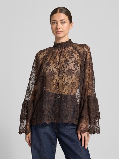 Modelka kobieca nosi Blusenshirt aus Spitze mit Stehkragen od Milano Italy z bawełnianą mieszanką, krój relaxed fit, półprzezroczysta koronka w kolorze brązowym, długość tyłu w rozmiarze 36: 66 cm, długość rękawa w rozmiarze 36: 64 cm, widok całej sylwetki z przodu.