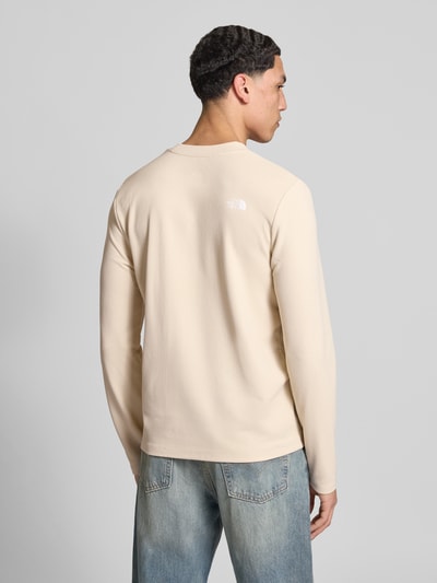 Męski model nosi bluzkę z długim rękawem z elastycznej mieszanki materiałów The North Face Langarmshirt mit Napoleontasche Modell 'KECHA', prosty krój, okrągły dekolt, detal z logo, długość tyłu w rozmiarze M: 67 cm, jasny kolor, struktura gładka, Ganzkörperansicht Rückansicht.